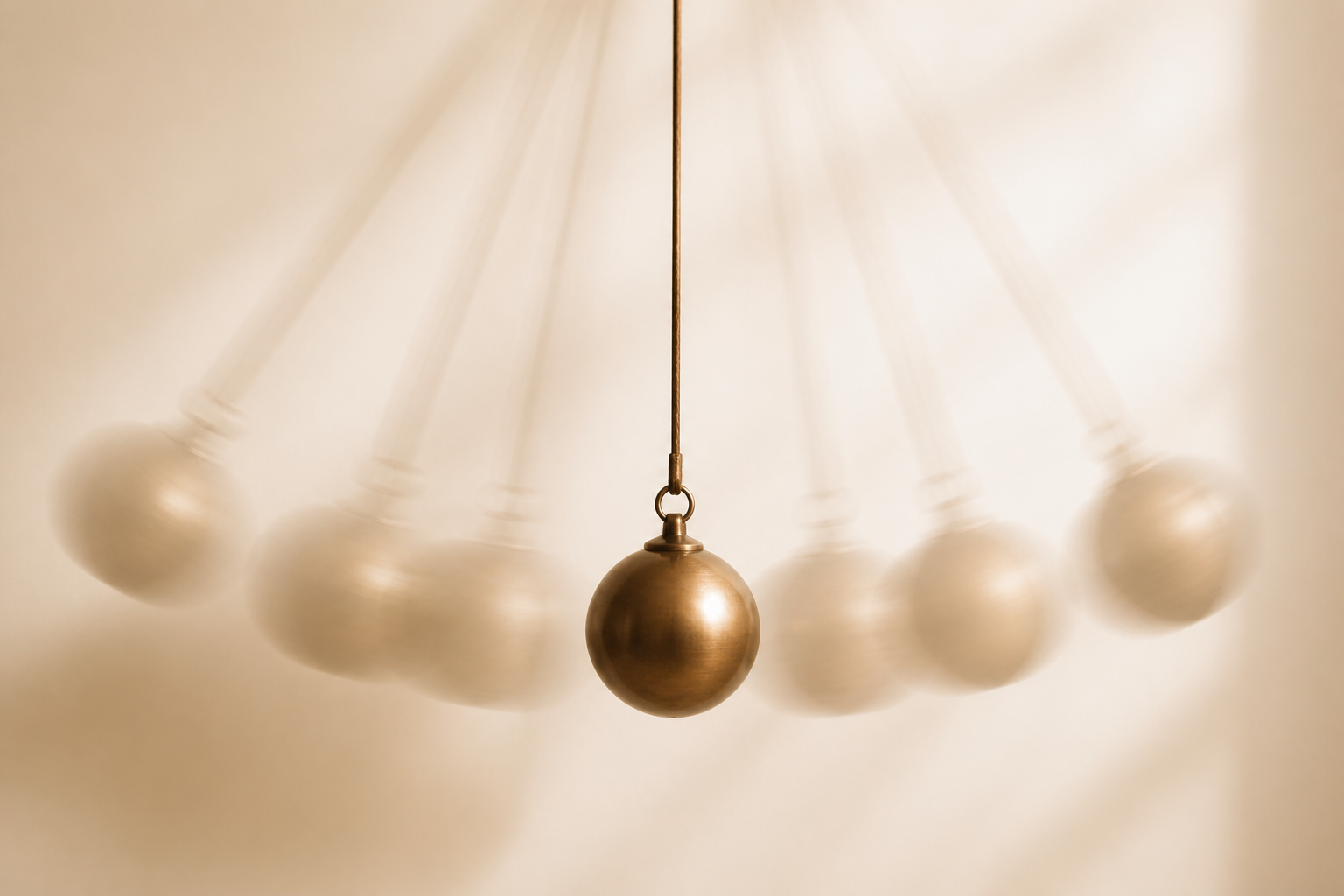 Abstract editorial image of a pendulum in soft motion against a warm cream background