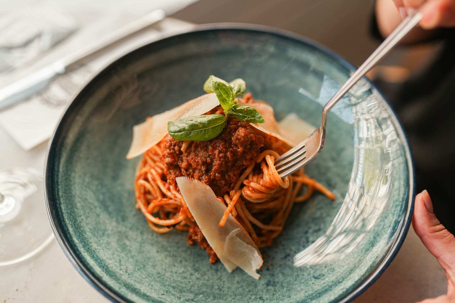 Hand with fork over dinner bowl