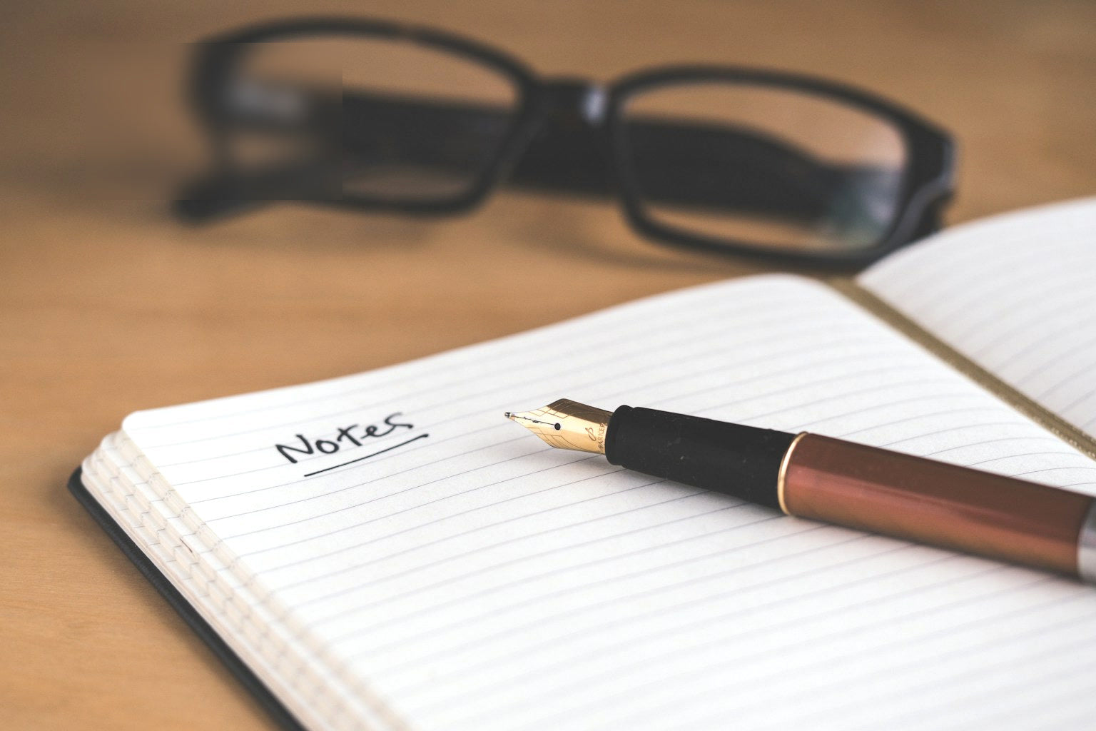 A notebook open to a food log page beside a pen on a clean table.