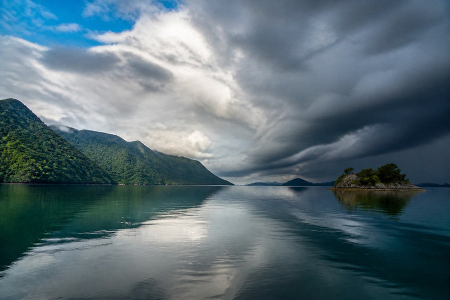 Storm clouds building over a Philippine coastal landscape, atmospheric editorial photography.