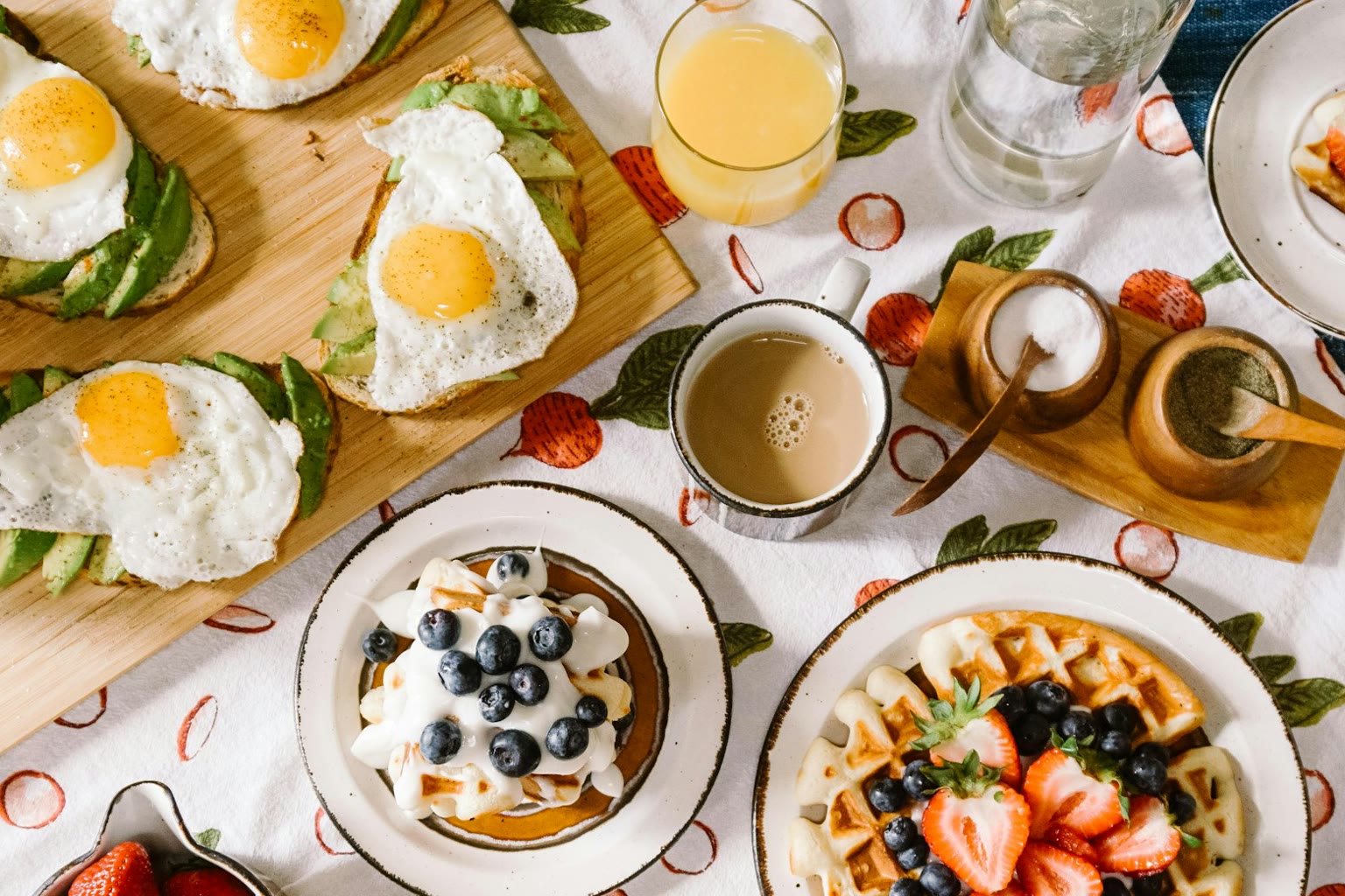 A simple breakfast plate with eggs and vegetables beside a glass of water.