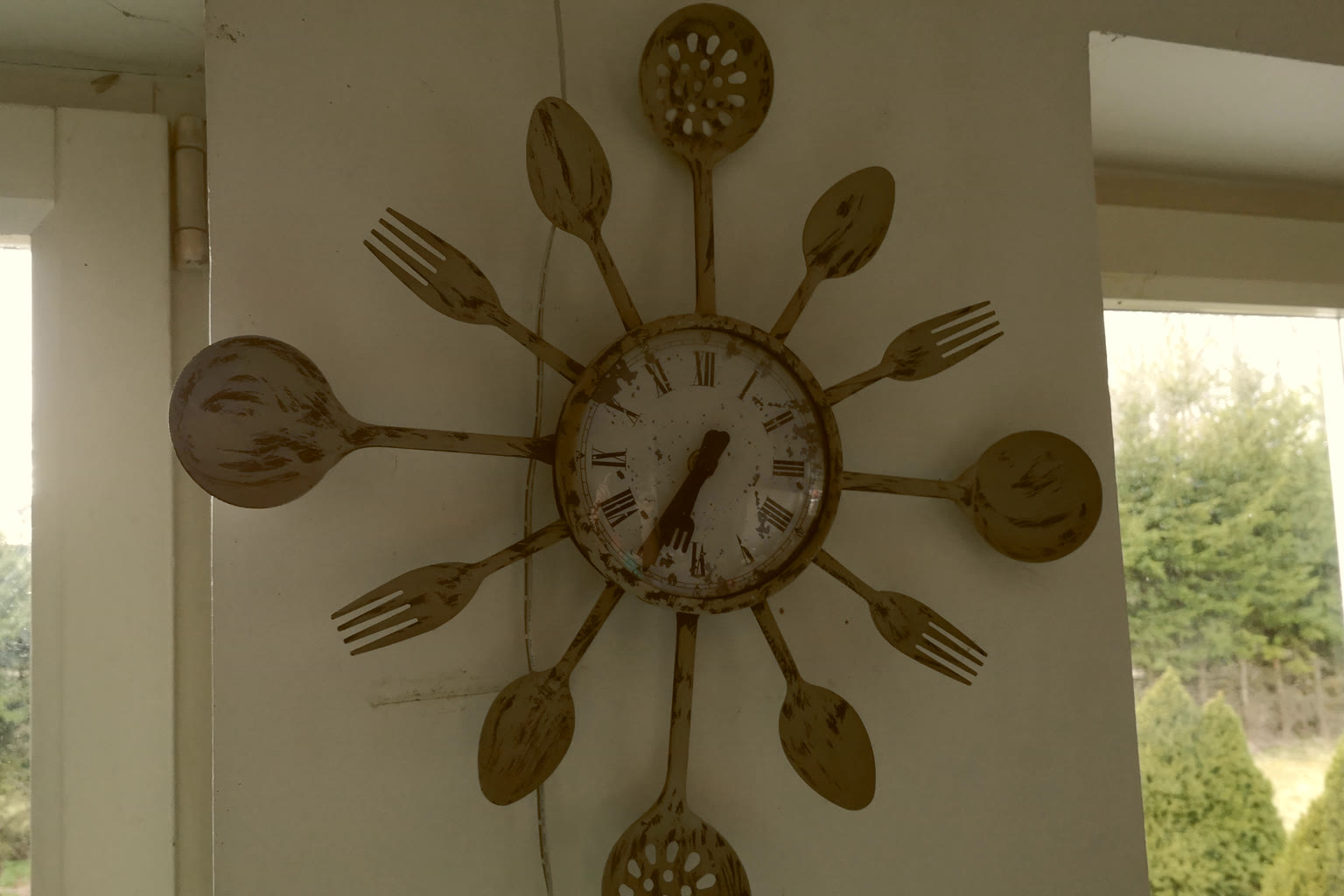 An analog clock on a kitchen wall suggesting a full day cycle of light and shadow.