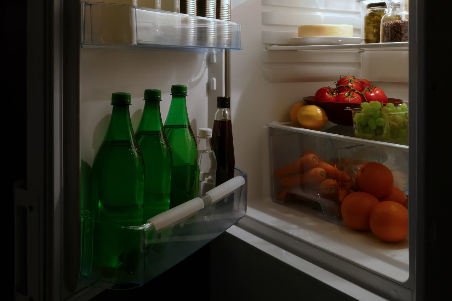 Open fridge at night hand reaching inside