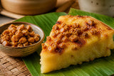 Bowl of toasted latik beside bibingka topped with latik