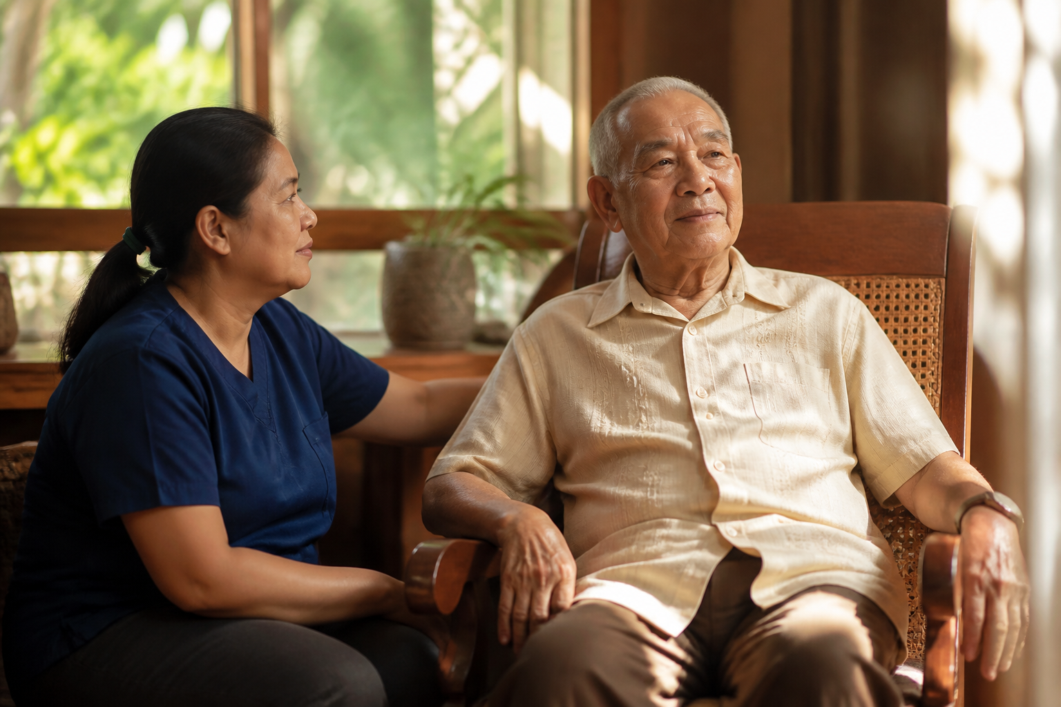 Filipino man in his 70s with a caretaker nearby