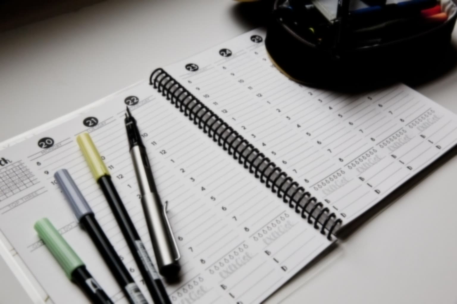 A simple weekly planner open on a table in soft morning light.