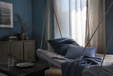 Quiet afternoon room with daybed near a window and drawn curtains