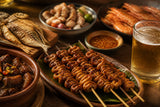 Filipino dishes including isaw skewers and a small glass of beer