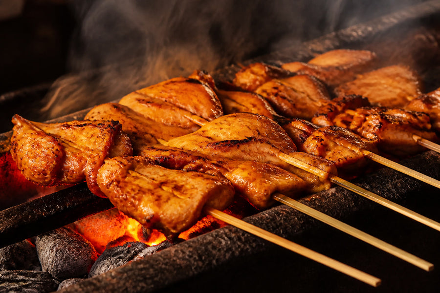 Inasal-style chicken skewers grilling over glowing charcoal